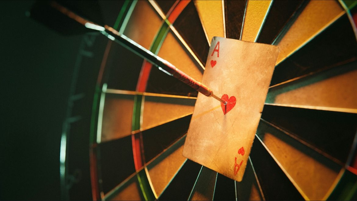 a closeup of a dart board with a card pinned on it by an arrow | © Julius Drost un Unsplash